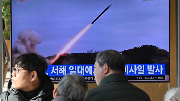 Pessoas assistem a tela televisiva mostrando um noticiário com imagens de arquivo de um teste de míssil norte-coreano, em uma estação de trem em Seul, Coreia do Sul, 24 de janeiro de 2024 - Sputnik Brasil