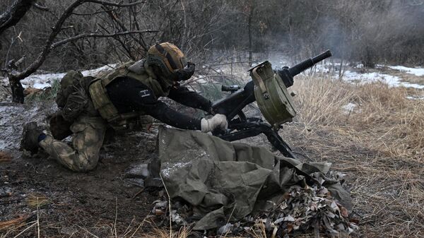 Militar das Forças Armadas da Rússia opera como parte do agrupamento de tropas Yug no flanco norte de Artyomovsk, dispara contra posições das Forças Armadas da Ucrânia com um lançador de granadas automático na zona da operação militar especial, em 20 de janeiro de 2024 - Sputnik Brasil