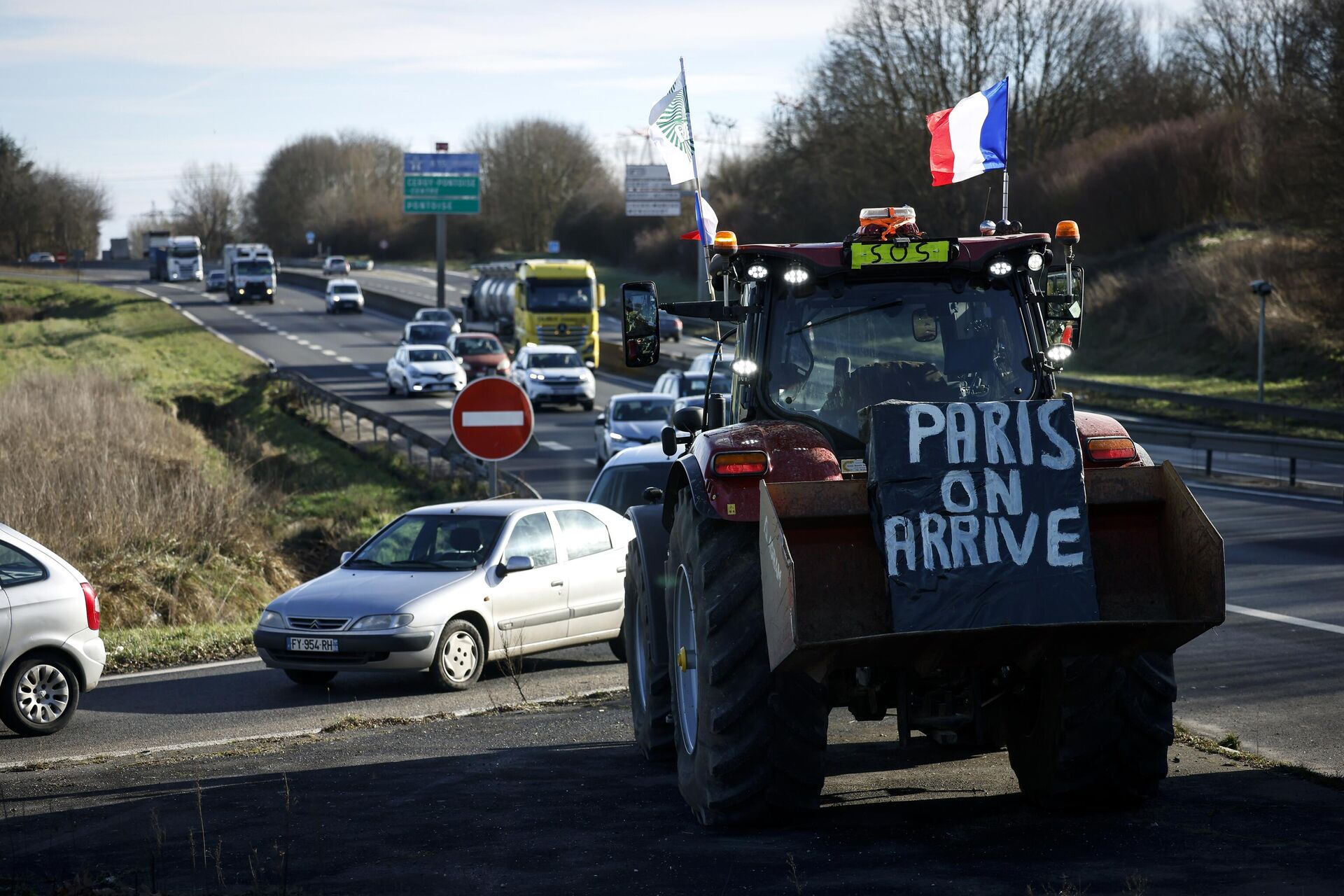 Cartaz pendurado em um trator diz Paris, estamos chegando, enquanto agricultores se preparam para bloquear uma rodovia perto de Ableiges, ao norte de Paris. França, 26 de janeiro de 2024 - Sputnik Brasil, 1920, 28.01.2024