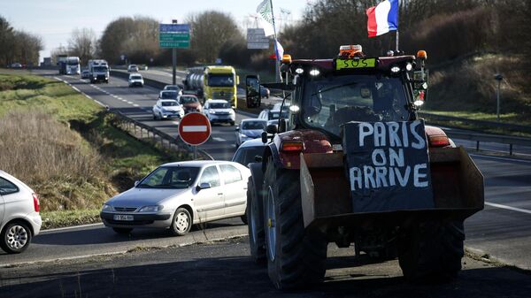 Cartaz pendurado em trator diz Paris, estamos chegando, enquanto agricultores se preparam para bloquear rodovia perto de Ableiges, ao norte de Paris. França, 26 de janeiro de 2024 - Sputnik Brasil