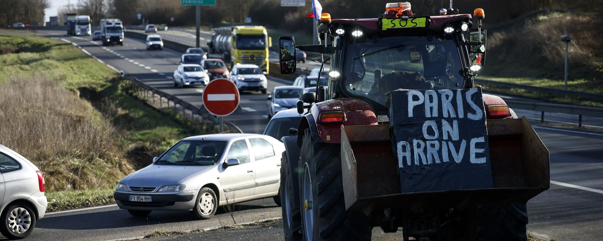 Cartaz pendurado em trator diz Paris, estamos chegando, enquanto agricultores se preparam para bloquear rodovia perto de Ableiges, ao norte de Paris. França, 26 de janeiro de 2024 - Sputnik Brasil, 1920, 14.10.2025