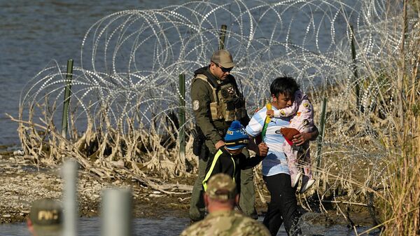 Imigrantes são levados sob custódia por autoridades em Eagle Pass, na fronteira entre o Texas e o México, EUA, 3 de janeiro de 2024 - Sputnik Brasil