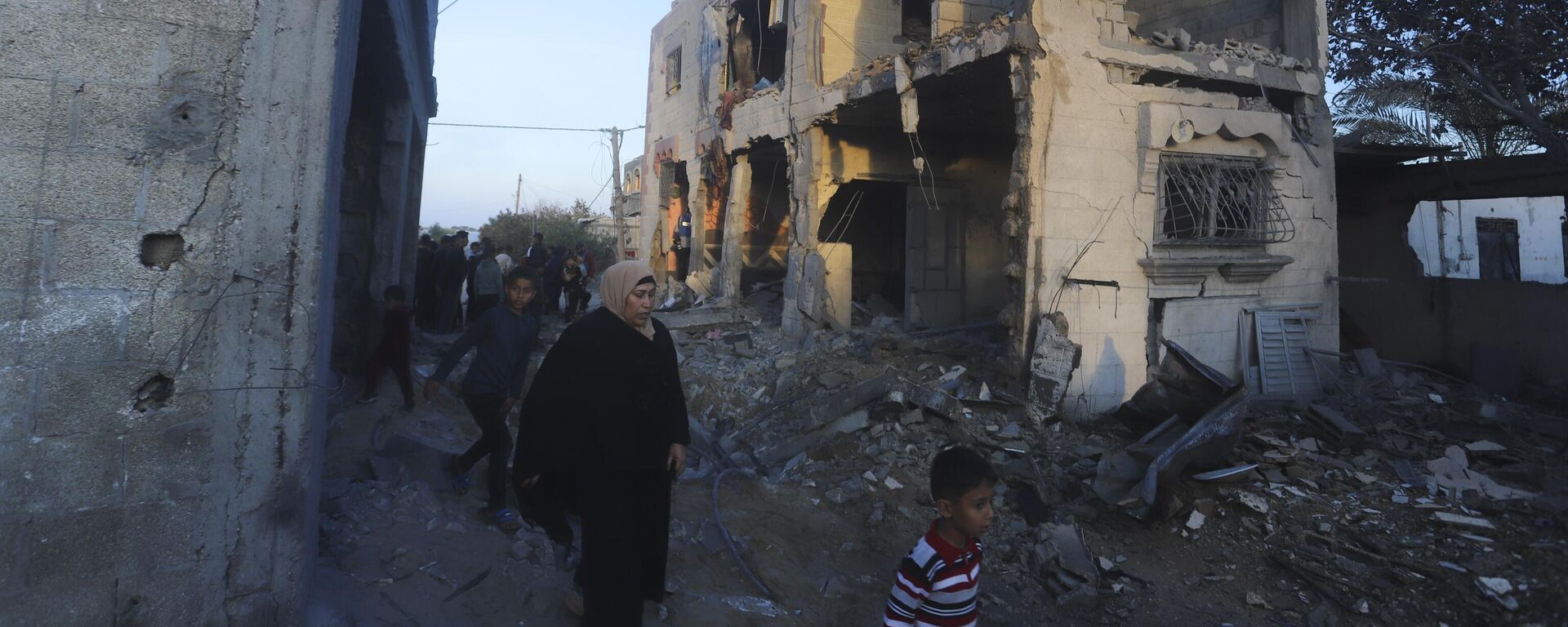 Palestinos passam por prédio residencial destruído em um ataque israelense em Rafah. Faixa de Gaza, 11 de fevereiro de 2024 - Sputnik Brasil, 1920, 17.02.2024