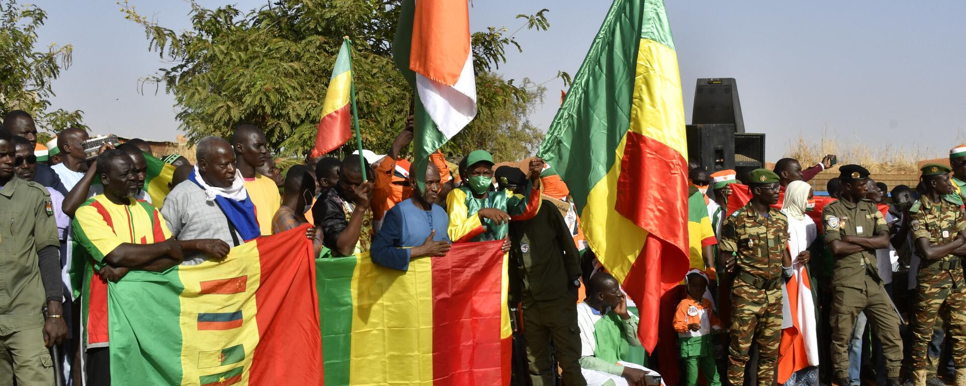 Pessoas brandem bandeiras do Níger, Mali e Burkina Faso durante uma reunião em Niamey, em 29 de dezembro de 2023 - Sputnik Brasil, 1920, 15.02.2024