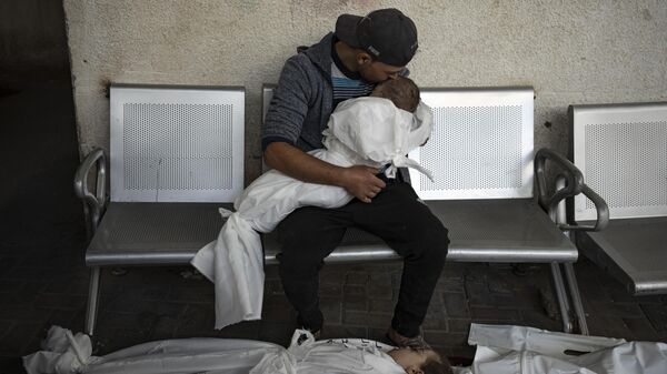 Palestinians mourn their relatives killed in the Israeli bombardment of the Gaza Strip, at the hospital Rafah, Gaza. - Sputnik Brasil