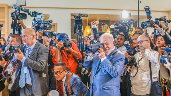 O presidente Luiz Inácio Lula da Silva segura câmera para foto dos chefes de Estado e autoridades durante cúpula da Comunidade dos Estados Latino-Americanos e Caribenhos (CELAC). São Vicente e Granadinas, 1º de março de 2024 - Sputnik Brasil