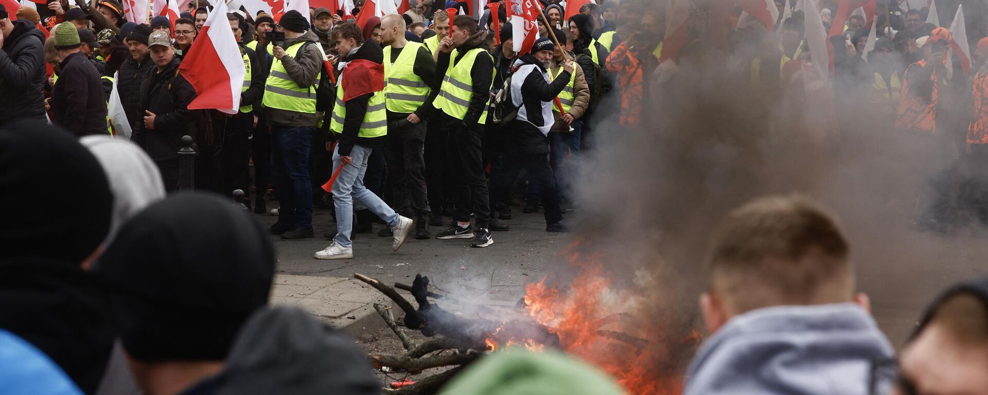 Agricultores poloneses se manifestam com fogos e bandeiras contra as medidas climáticas da UE e as importações ucranianas em frente ao edifício do Parlamento em Varsóvia. Polônia, 6 de março de 2024 - Sputnik Brasil, 1920, 06.03.2024