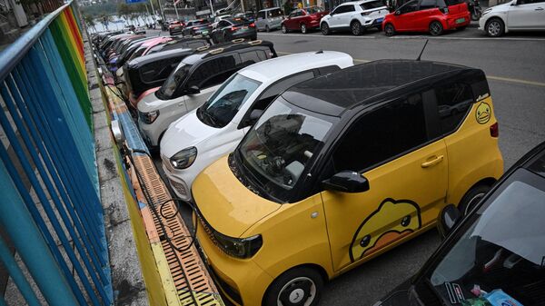 Pequenos veículos elétricos carregando em uma rua de Liuzhou, na província de Guangxi, China, 24 de janeiro de 2024 - Sputnik Brasil