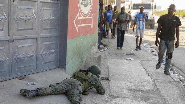 Pedestres passam por soldado que monitora a área próxima ao Aeroporto Internacional de Porto Príncipe. Haiti, 4 de março de 2024 - Sputnik Brasil