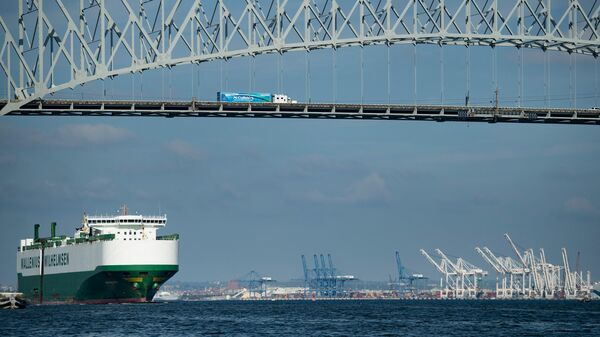 Um navio de carga passa abaixo da ponte Francis Scott Key ao sair do porto de Baltimore, Maryland, 14 de outubro de 2021 - Sputnik Brasil