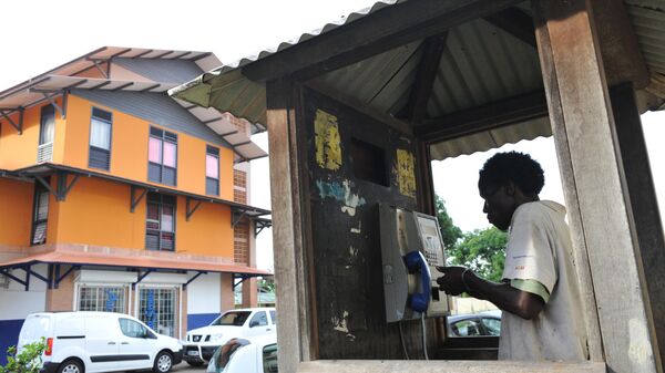 Morador da cidade de Caiena, capital da Guiana Francesa, em uma cabine telefônica - Sputnik Brasil