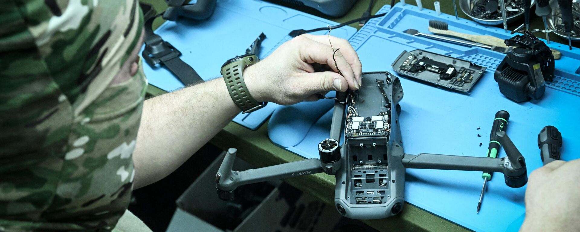 Um militar das Forças Armadas russas trabalha, aprendendo dados úteis, em um drone ucraniano capturado - Sputnik Brasil, 1920, 24.06.2025