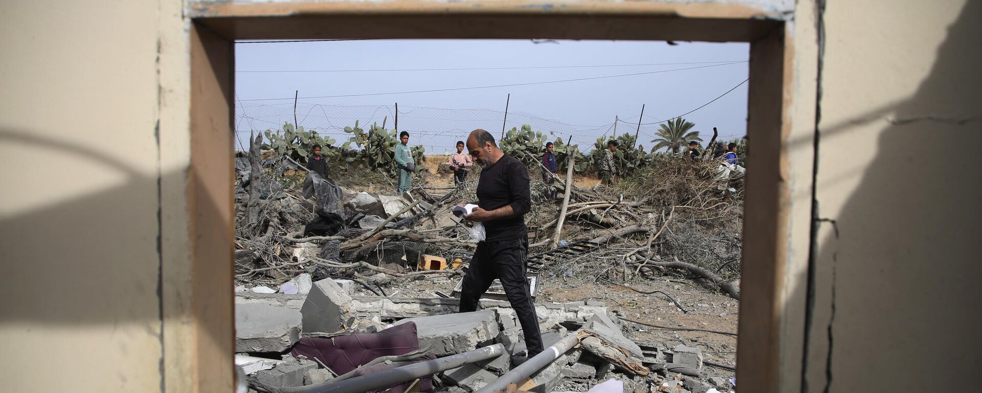 Palestinos inspecionam as ruínas de um prédio residencial após ataque aéreo israelense em Rafah, Faixa de Gaza, em 29 de março de 2024 - Sputnik Brasil, 1920, 30.04.2024