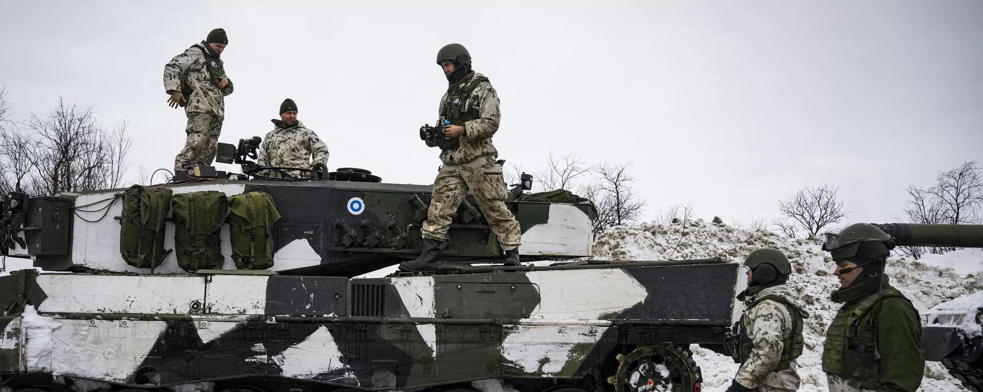 Soldados finlandeses em pé sobre um tanque Leopard 2A6, no lado finlandês da travessia de fronteira de Kivilompolo entre a Finlândia e a Noruega, além do Círculo Polar Ártico, em 9 de março de 2024 - Sputnik Brasil, 1920, 12.04.2024