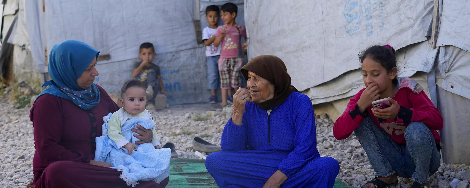 Família síria sentada em frente à sua tenda em um campo de refugiados na cidade de Bar Elias, no Vale do Bekaa, no Líbano, em 13 de junho de 2023 - Sputnik Brasil, 1920, 14.04.2024