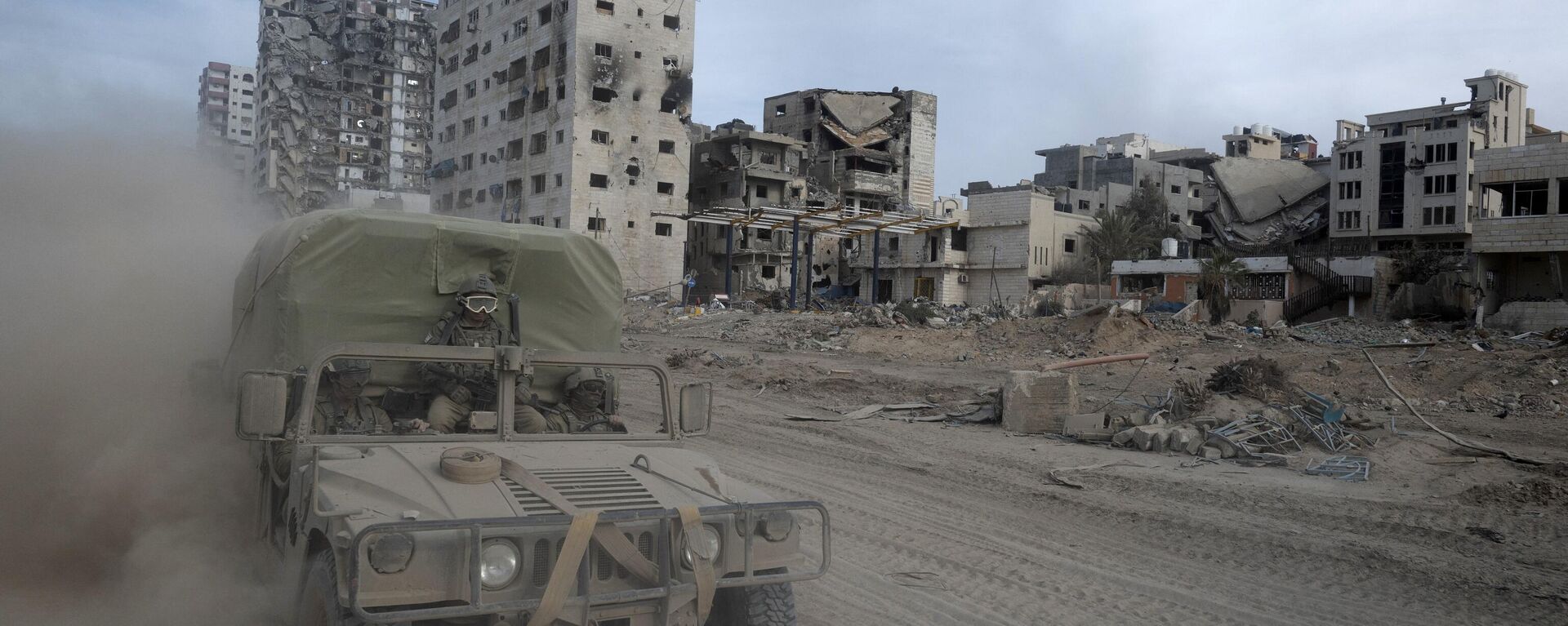 Tropas israelenses passam em um veículo por edifícios danificados durante uma operação militar no norte da Faixa de Gaza em meio a contínuas batalhas entre Israel e o grupo militante palestino Hamas, em 22 de novembro de 2023 - Sputnik Brasil, 1920, 23.04.2024