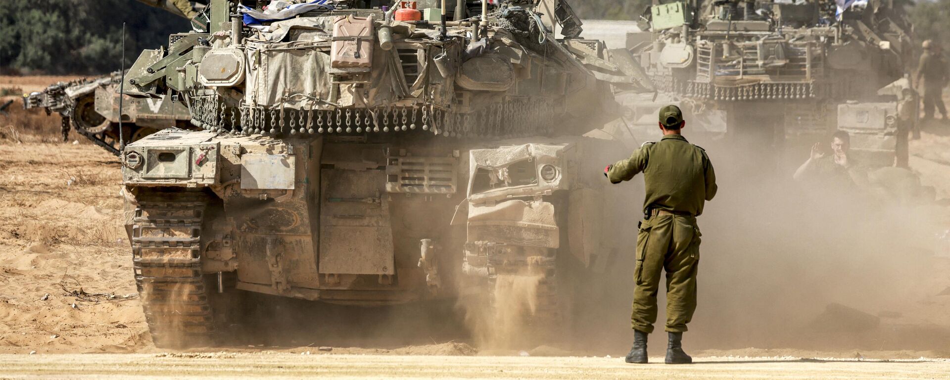 Soldado do Exército israelense atrás de um tanque em movimento enquanto as forças se reúnem em uma posição perto da fronteira com a Faixa de Gaza, no sul de Israel, em 30 de abril de 2024 - Sputnik Brasil, 1920, 03.05.2024