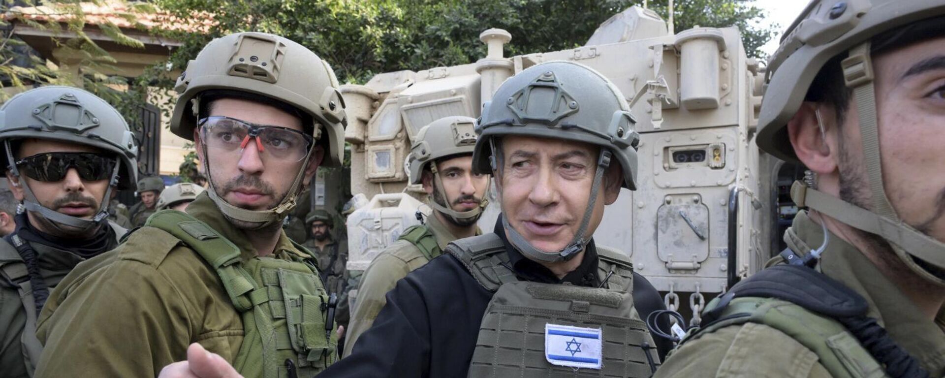 O primeiro-ministro israelense, Benjamin Netanyahu, ao centro, usa colete protetor e capacete ao receber instruções de segurança com comandantes e soldados no norte da Faixa de Gaza, 25 de dezembro de 2023 - Sputnik Brasil, 1920, 01.05.2024