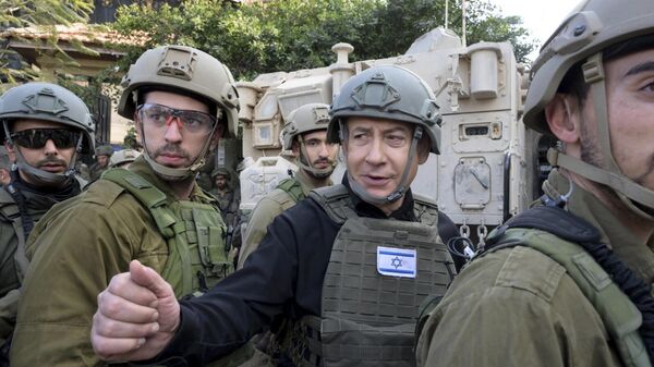 O primeiro-ministro israelense, Benjamin Netanyahu, ao centro, usa colete protetor e capacete ao receber instruções de segurança com comandantes e soldados no norte da Faixa de Gaza, em 25 de dezembro de 2023 - Sputnik Brasil