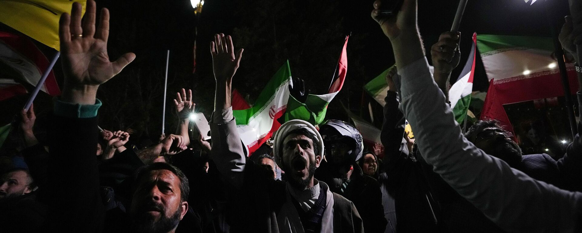 Manifestantes iranianos entoam slogans durante uma reunião anti-israelense em frente à Embaixada do Reino Unido em Teerã, Irã, 14 de abril de 2024 - Sputnik Brasil, 1920, 15.03.2026