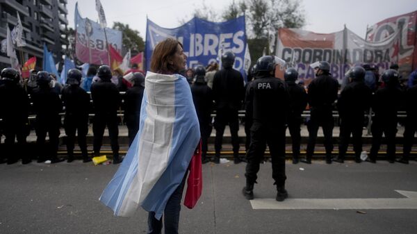 Manifestante se enrola em uma bandeira argentina durante um protesto contra a escassez de alimentos em cozinhas comunitárias e as reformas econômicas propostas pelo presidente Javier Milei em Buenos Aires, Argentina. 7 de maio de 2024. - Sputnik Brasil