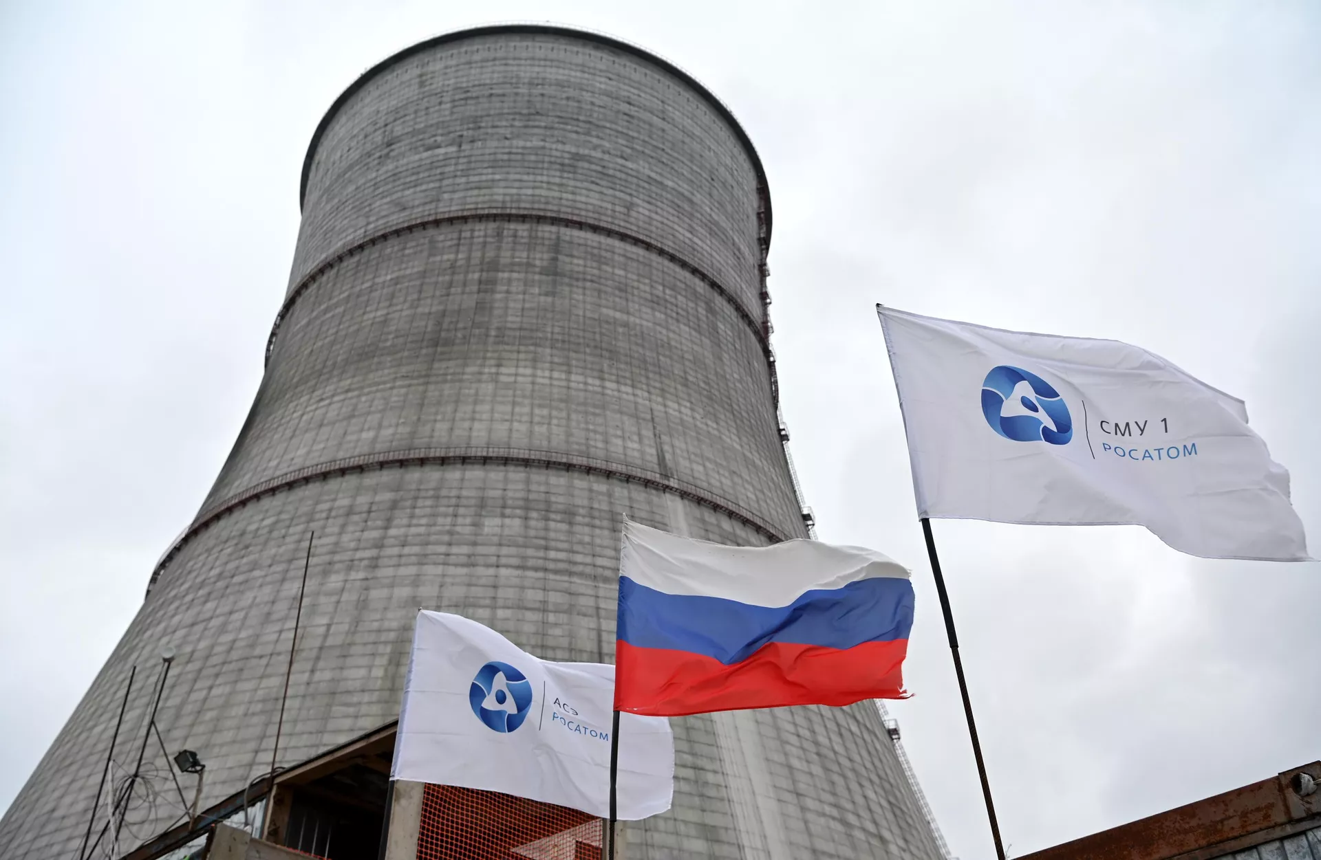 Uma bandeira nacional russa e bandeiras com o logotipo da Rosatom tremulam no canteiro de obras de uma torre de resfriamento na usina nuclear Kursk II, perto da vila de Makarovka, nos arredores de Kurchatov, região de Kursk - Sputnik Brasil, 1920, 22.07.2024