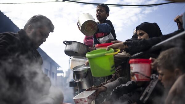 Palestinos fazem fila para receber refeição gratuita em Rafah, Faixa de Gaza, 16 de fevereiro de 2024 - Sputnik Brasil