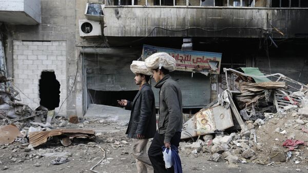 Homens sírios carregam sacos de pão na cabeça enquanto caminham de volta para suas casas no bairro de Bustan al-Qasr, no leste de Aleppo. Síria, 20 de janeiro de 2017 - Sputnik Brasil