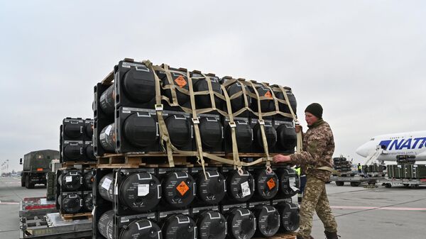 Um militar ucraniano trabalhando para receber a entrega de mísseis antitanque portáteis Javelins FGM-148 norte-americanos fornecidos pelos EUA à Ucrânia como parte de um apoio militar, no aeroporto Borispol de Kiev, 11 de fevereiro de 2022 - Sputnik Brasil