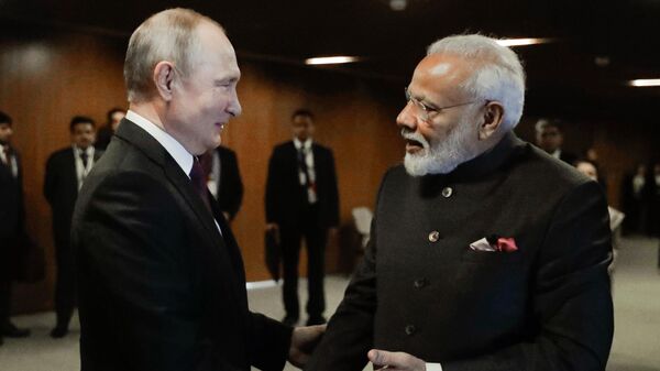 O primeiro-ministro da Índia, Narendra Modi, à direita, aperta a mão do presidente da Rússia, Vladimir Putin, durante uma reunião à margem da 11ª Cúpula do BRICS em Brasília, Brasil - Sputnik Brasil