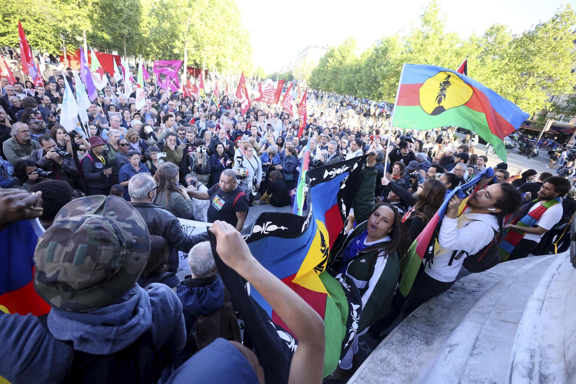 Manifestantes seguram bandeiras kanak e da Frente de Libertação Nacional Kanak e Socialista (FLNKS) durante ato público em Paris, em 16 de maio de 2024 - Sputnik Brasil, 1920, 17.05.2024