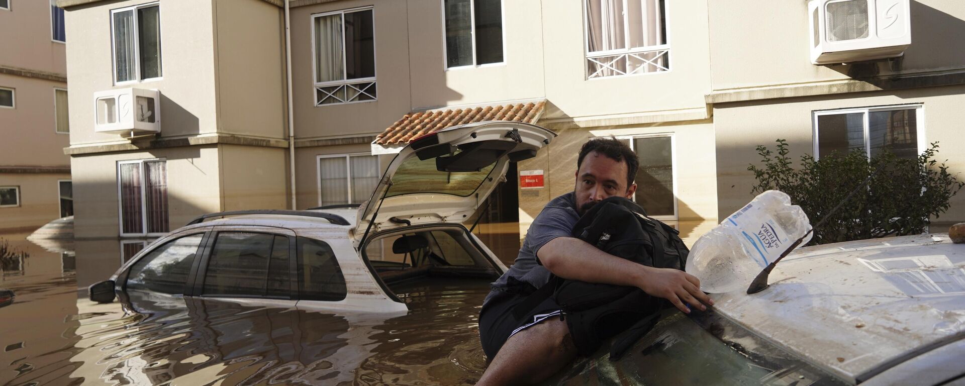 Homem se apoia em carro enquanto tenta retornar ao seu prédio inundado após fortes chuvas em Canoas (RS), em 9 de maio de 2024 - Sputnik Brasil, 1920, 21.05.2024