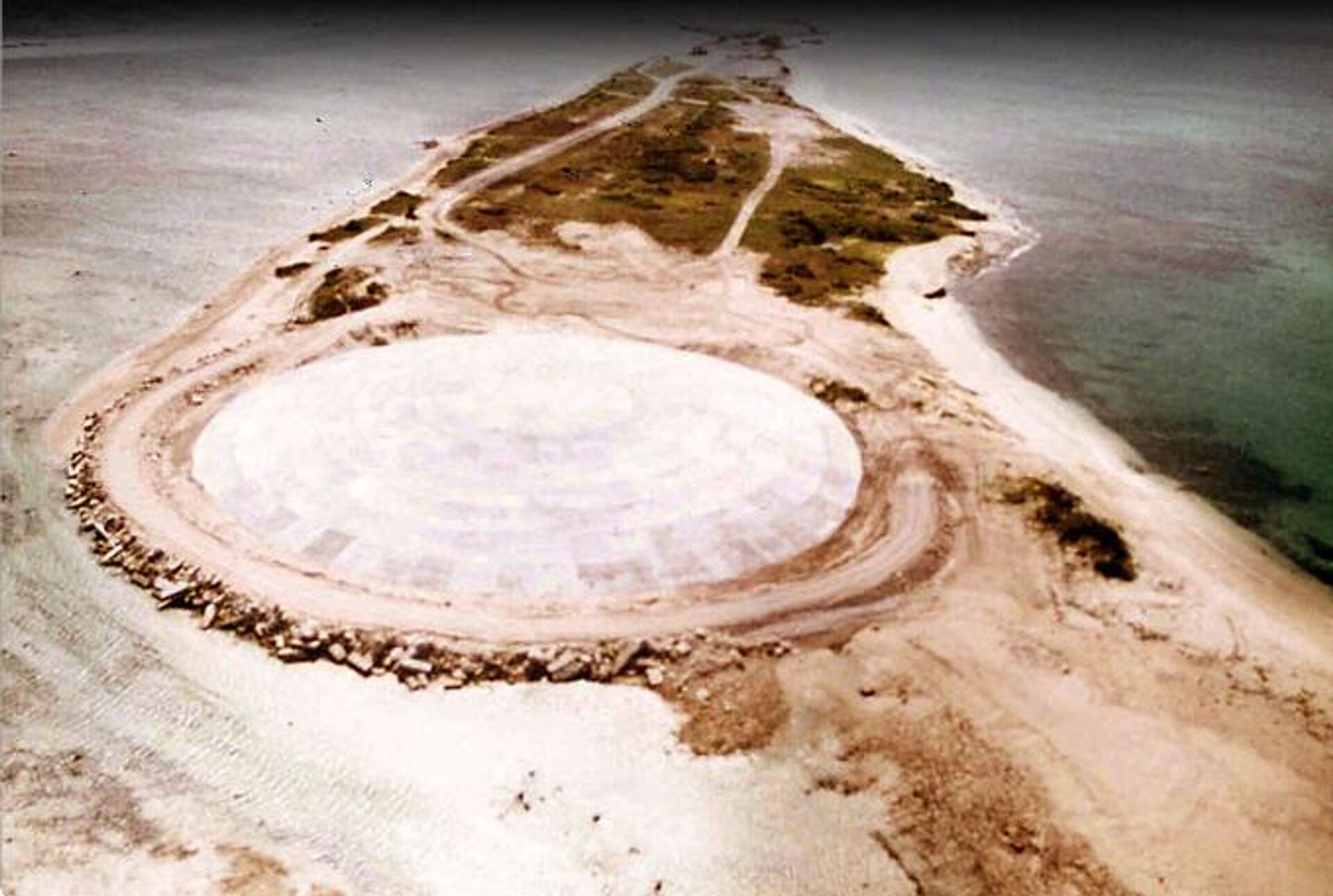 Foto tirada pela Agência Nuclear de Defesa dos EUA em 1980, mostra a enorme cúpula construída sobre uma cratera deixada por um dos 43 testes nucleares sobre a ilha Runit, em Enewetak, nas Ilhas Marshall.  - Sputnik Brasil, 1920, 24.05.2024