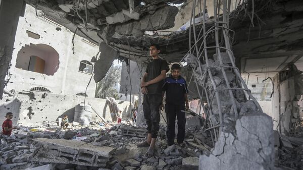 Palestinos observam ruínas de uma casa após um ataque israelense noturno que matou pelo menos dois adultos e cinco meninos e meninas menores de 16 anos em Rafah. Faixa de Gaza, 3 de maio de 2024 - Sputnik Brasil
