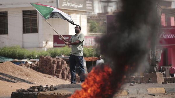 Homem agita bandeira do Sudão enquanto protesta na capital, Cartum, em 30 de outubro de 2021 - Sputnik Brasil