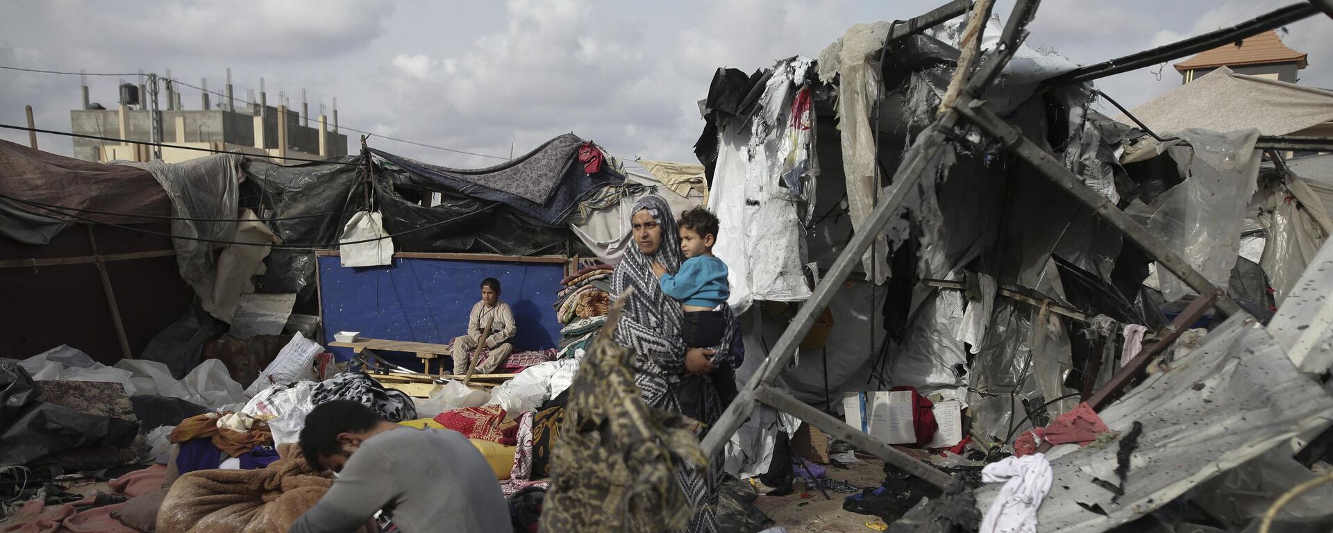 Palestinos deslocados inspecionam suas tendas destruídas por um bombardeio de Israel, no oeste da cidade de Rafah. Faixa de Gaza, 28 de maio de 2024 - Sputnik Brasil, 1920, 04.06.2024