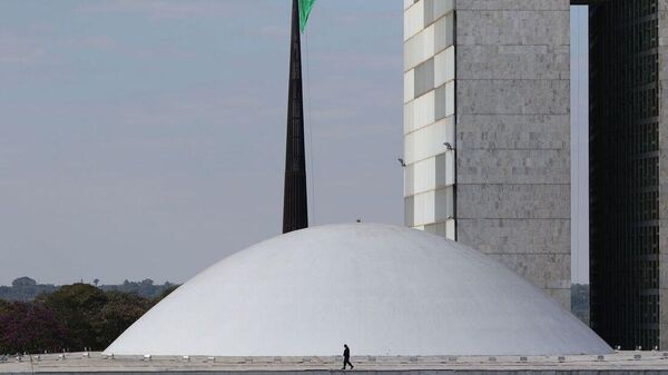 Homem caminha em frente ao Senado Federal, em Brasília - Sputnik Brasil