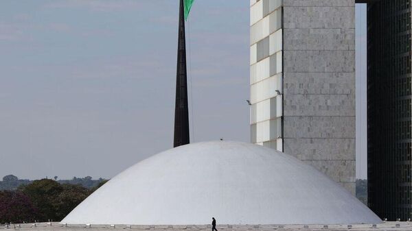 Homem caminha em frente ao Senado Federal, em Brasília - Sputnik Brasil