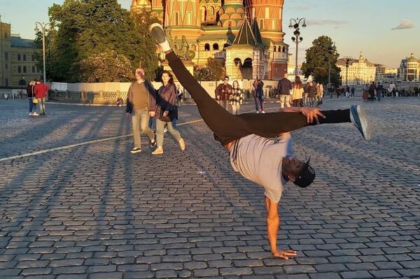 Dançarino e residente na Rússia há mais de 20 anos, o brasileiro Antonio Claudio Luz Silva, conhecido como Kakau, joga capoeira na Praça Vermelha, em Moscou, em junho de 2024 - Sputnik Brasil