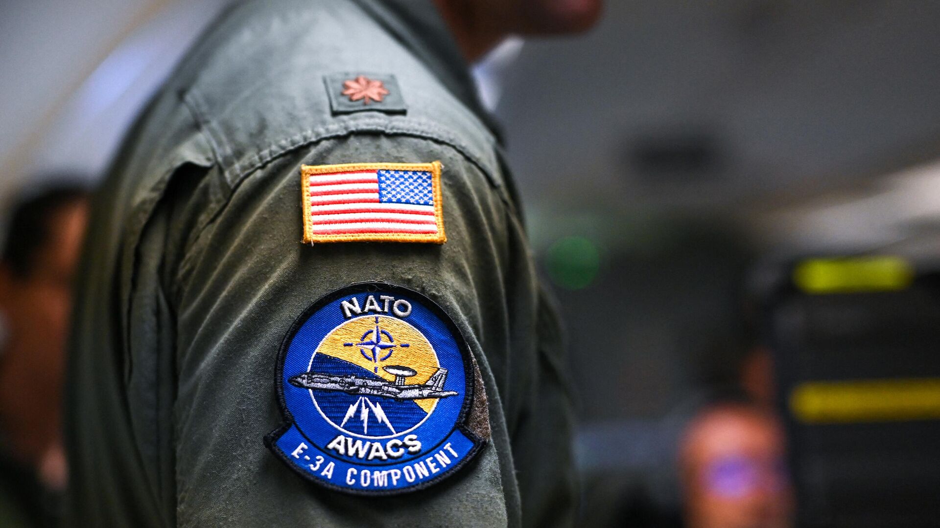 Um operador usa a bandeira dos EUA e um emblema AWACS da OTAN em seu uniforme em uma aeronave do Sistema de Alerta e Controle Aéreo (AWACS) da OTAN, que participa do exercício multinacional liderado pela Alemanha Air Defender 23, durante um voo sobre o norte da Alemanha a partir da base militar de Geilenkirchen, oeste da Alemanha, em 20 de junho de 2023 - Sputnik Brasil, 1920, 06.06.2024