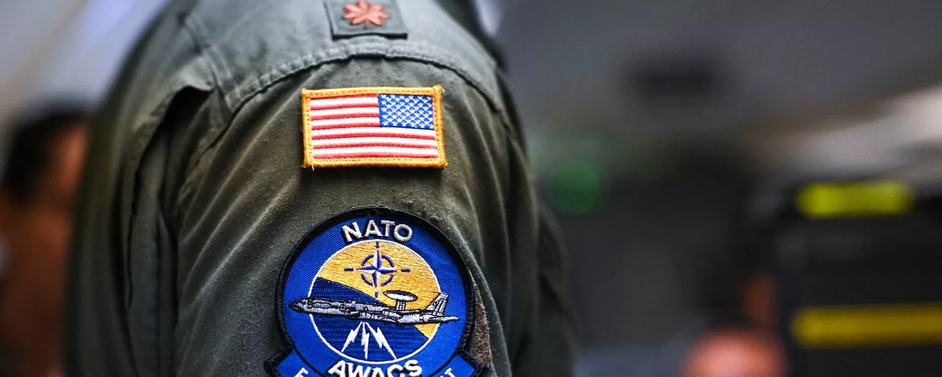 Um operador usa a bandeira dos EUA e um emblema AWACS da OTAN em seu uniforme em uma aeronave do Sistema de Alerta e Controle Aéreo (AWACS) da OTAN, que participa do exercício multinacional liderado pela Alemanha Air Defender 23, durante um voo sobre o norte da Alemanha a partir da base militar de Geilenkirchen, oeste da Alemanha, em 20 de junho de 2023 - Sputnik Brasil, 1920, 06.06.2024