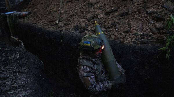 Militar ucraniano carrega projétil enquanto se prepara com seus companheiros para disparar um obuseiro rebocado leve M777 contra posições russas, no front de Donetsk, 7 de maio de 2024 - Sputnik Brasil