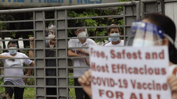 Trabalhadores da saúde nas Filipinas fazem protesto em frente a uma unidade de saúde e pedem vacinas gratuitas, seguras e mais eficazes contra a COVID-19. Quezon, 17 de junho de 2024 - Sputnik Brasil