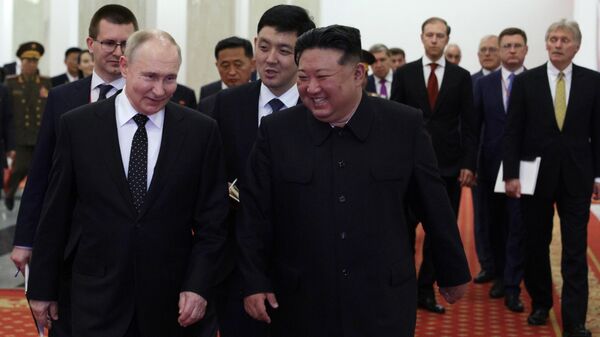 Em primeiro plano, o presidente russo Vladimir Putin (E) caminha junto ao líder norte-coreano Kim Jong-un (D) e comitiva durante sua visita à Coreia do Norte, 19 de junho de 2024 - Sputnik Brasil