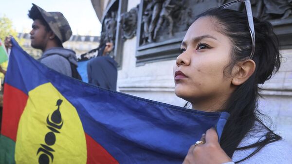 Manifestante segura bandeira não oficial da Nova Caledônia durante protesto em Paris em solidariedade ao território, em 16 de maio de 2024 - Sputnik Brasil