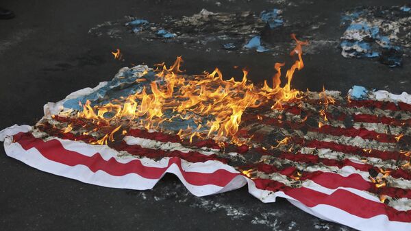 Bandeira dos EUA improvisada é incendiada por manifestantes durante um comício em frente à antiga Embaixada dos EUA, em comemoração ao aniversário de sua apreensão em 1979 em Teerã. Irã, 4 de novembro de 2021 - Sputnik Brasil