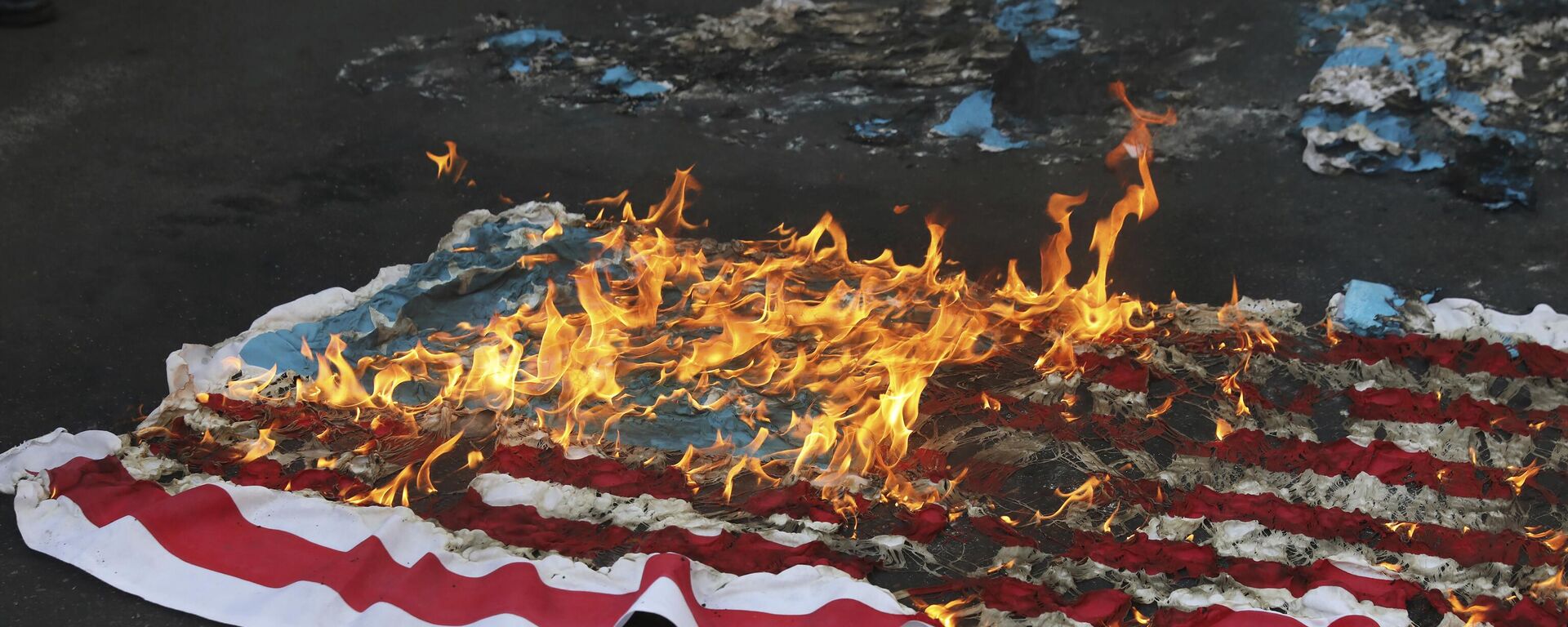 Bandeira dos EUA improvisada é incendiada por manifestantes durante um comício em frente à antiga Embaixada dos EUA, em comemoração ao aniversário de sua apreensão em 1979 em Teerã. Irã, 4 de novembro de 2021 - Sputnik Brasil, 1920, 28.06.2024