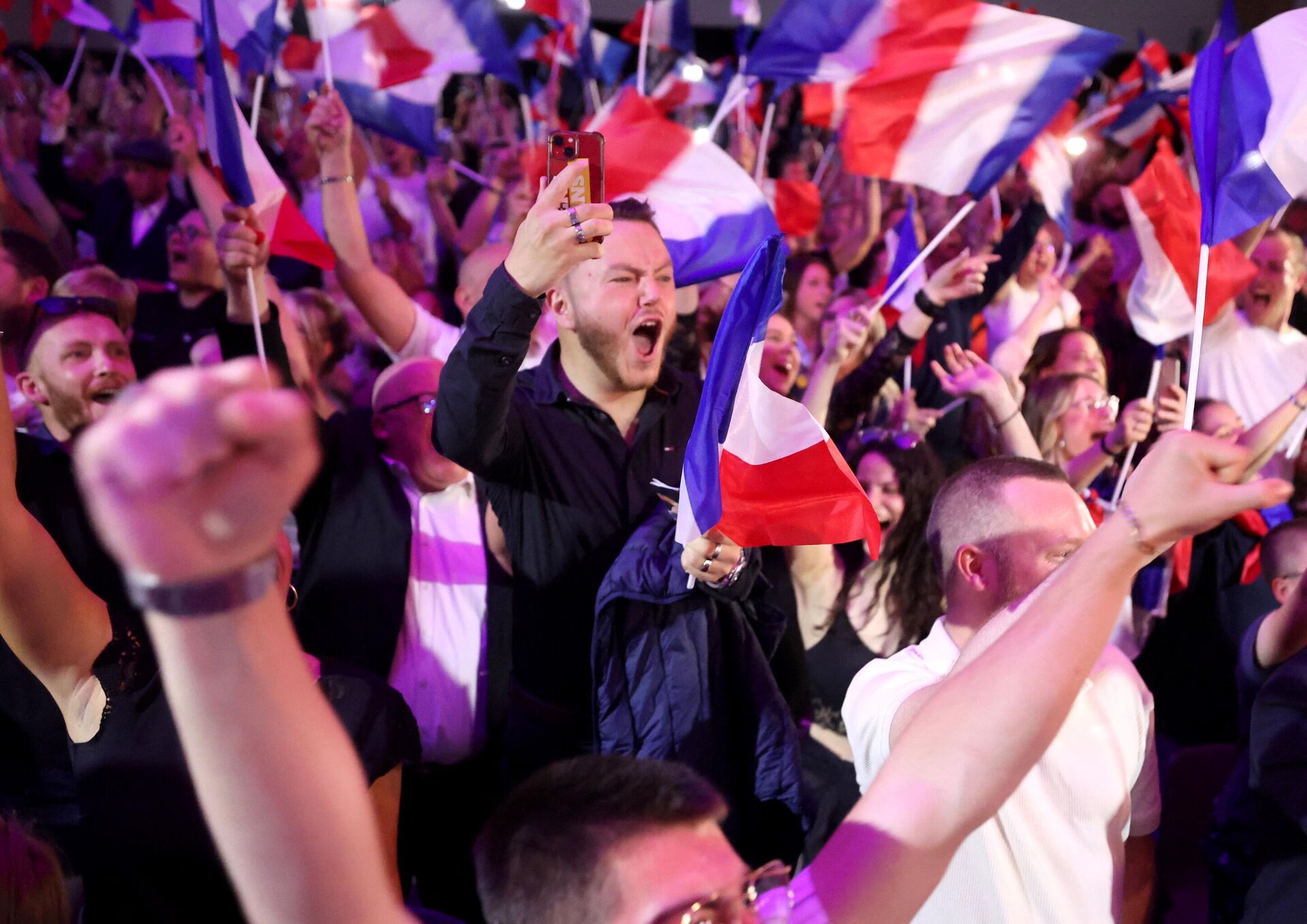 Apoiadores reagem enquanto a ex-presidente do grupo parlamentar de direita francês Reagrupamento Nacional (RN), Marine Le Pen, faz um discurso durante a noite de resultados do primeiro turno das eleições parlamentares em Henin-Beaumont, norte da França, 30 de junho de 2024 - Sputnik Brasil, 1920, 04.07.2024