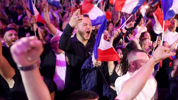 Apoiadores reagem enquanto a ex-presidente do grupo parlamentar de direita francês Reagrupamento Nacional (RN), Marine Le Pen, faz um discurso durante a noite de resultados do primeiro turno das eleições parlamentares em Henin-Beaumont, norte da França, 30 de junho de 2024 - Sputnik Brasil
