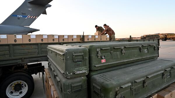 Militares da Ucrânia carregam um caminhão com caixas enquanto mísseis FIM-92 Stinger (dianteiros) fabricados nos EUA e um sistema de defesa aérea portátil (MANPADS) são empilhados após serem enviados para o aeroporto Boryspil em Kiev, 13 de fevereiro de 2022 - Sputnik Brasil
